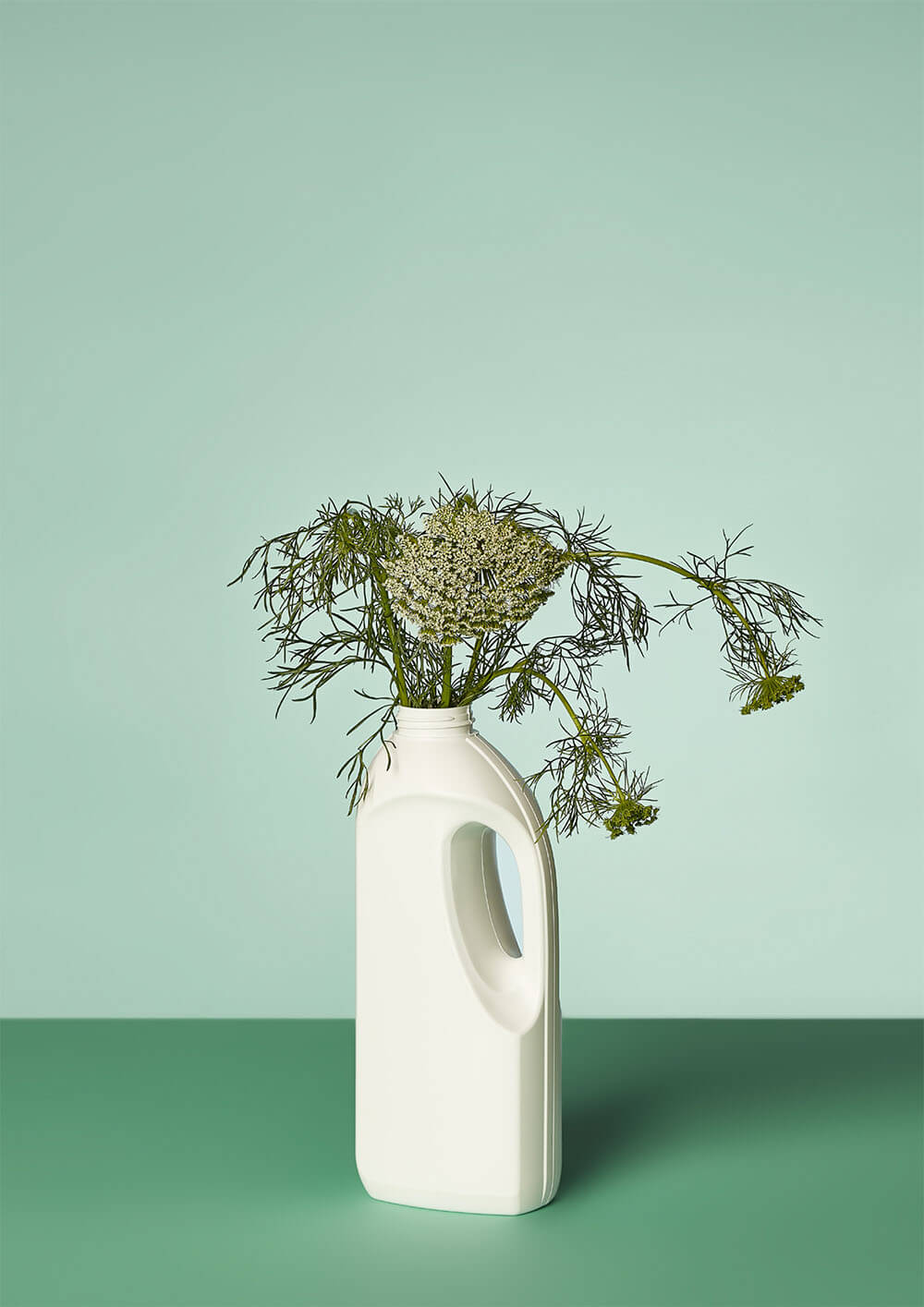 Vanessa Leissring - zdjęcie kwiatów w plastikowej butelce w zielonej kolorystyce